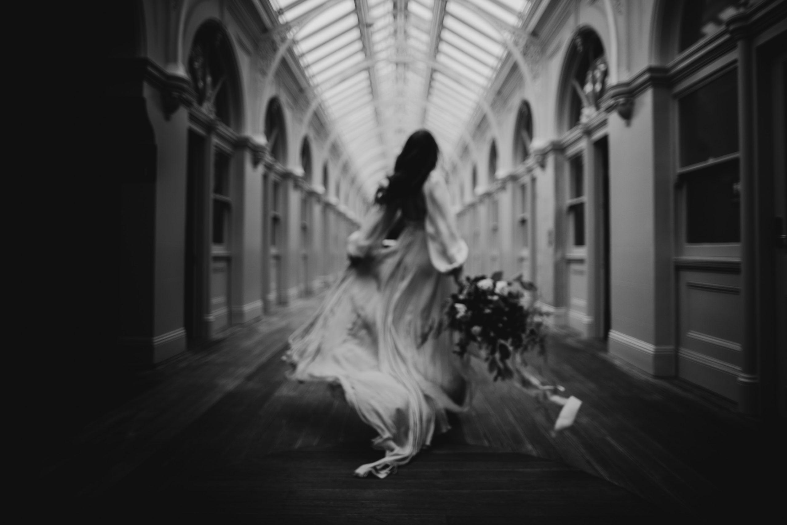 Bride running through a corridor at the Beehive Building Bendigo. Dark and moody wedding inspiration for the modern bride.
